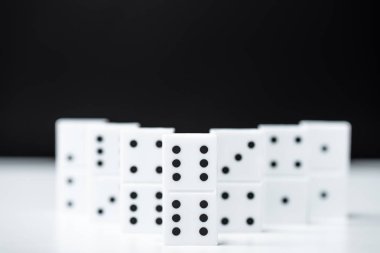selective focus of domino row isolated on black with copy space clipart