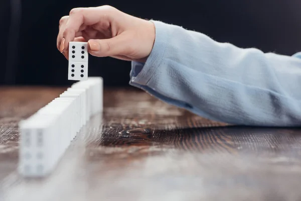 Pemandangan Perempuan Memetik Domino Dari Baris Atas Meja Kayu Terisolasi — Stok Foto