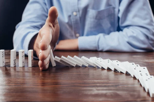 Partial View Man Preventing Dominoes Falling Wooden Desk — Stock Photo, Image
