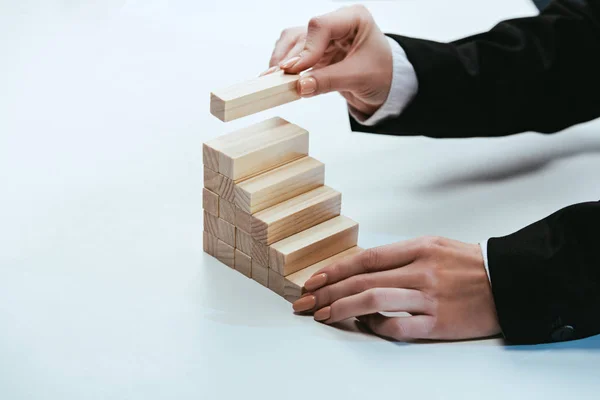 Cropped View Woman Putting Wooden Brick Top Wooden Blocks Symbolizing — Stock Photo, Image