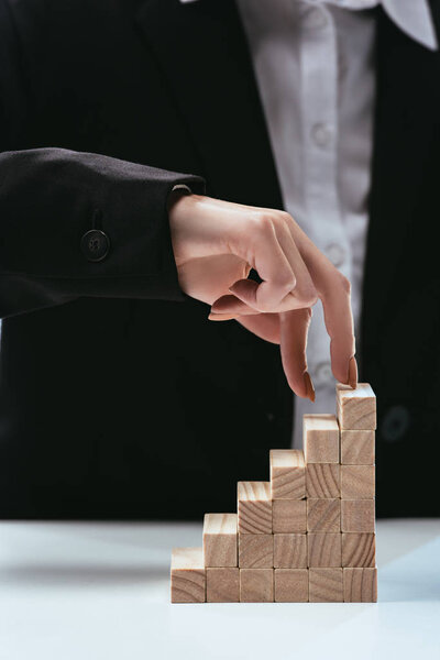 cropped view of woman walking with fingers on wooden blocks symbolizing career ladder