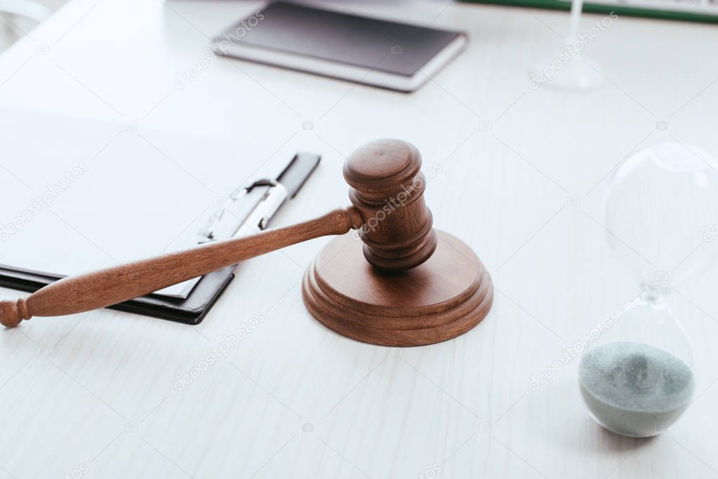 selective focus of wooden gavel near objects on table 