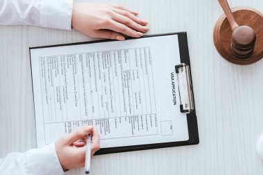 üstten görünüm belge vize uygulaması yazı ile kalemin tutan kadın 