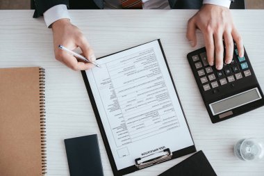 bir hesap makinesi üzerinde belge kalemin tutarken sayma adam üstten görünüm 
