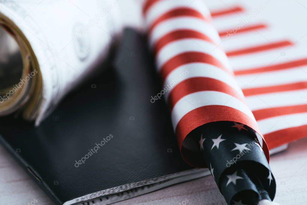 close up of american flag near passport and dollar banknotes 