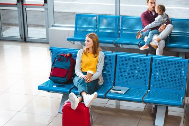 Kağıt bardak Havaalanı'nın yakınlarında sırt çantası insanlar ile arka planda tutan gülümseyen kadın seçici odak 