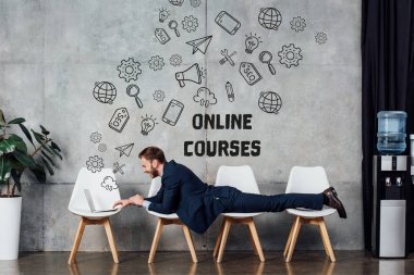 sandalyelere yalan ve duvara yazı online kurslar ile bekleme salonunda dizüstü kullanarak iş adamı