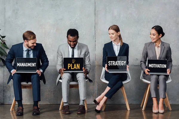 Усміхнені Багатоетнічні Бізнесмени Сидять Стільцях Тримають Ноутбуки Планом Стратегією Управлінням — стокове фото