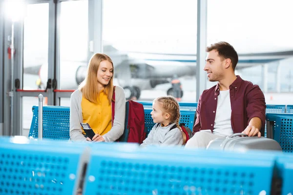 Glückliche Mutter Schaut Tochter Während Sie Mit Ehemann Wartezimmer Sitzt — Stockfoto