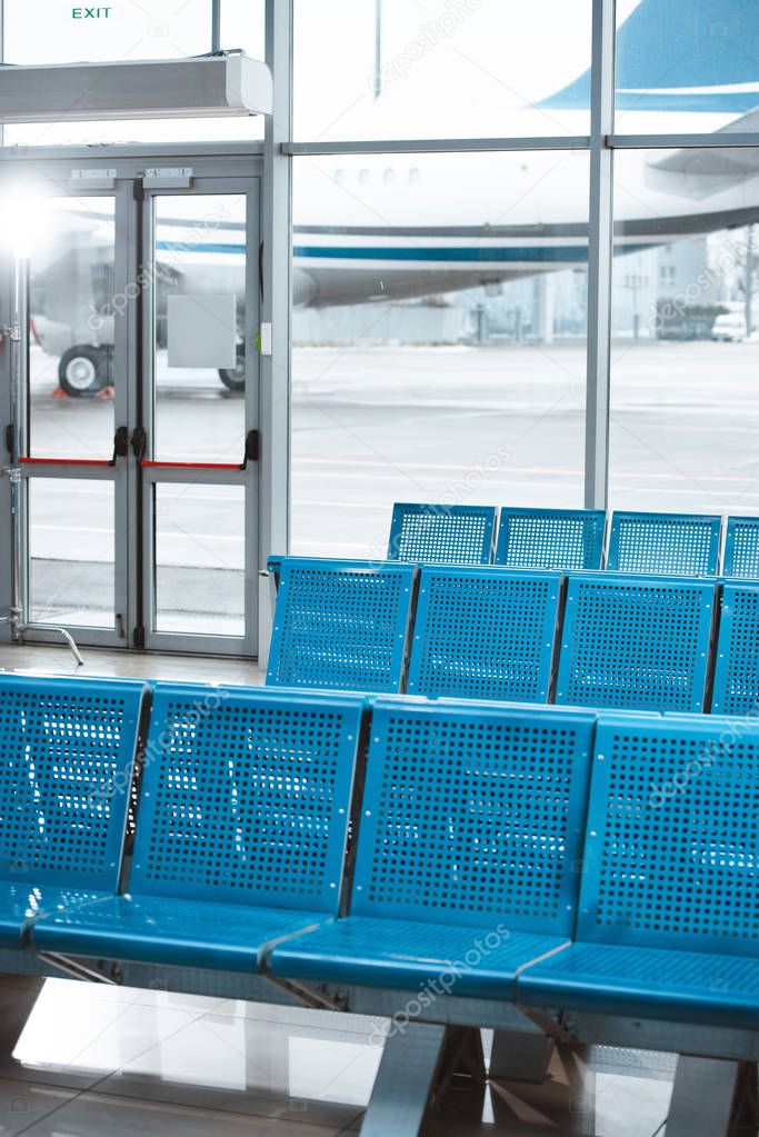 empty departure lounge with blue metallic seats in airport 