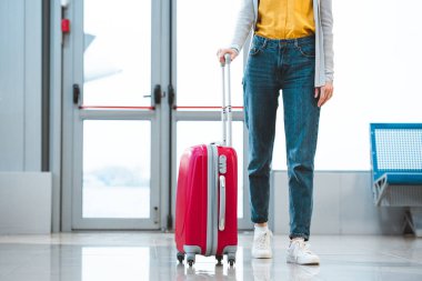 cropped view of woman standing with baggage in airport  clipart