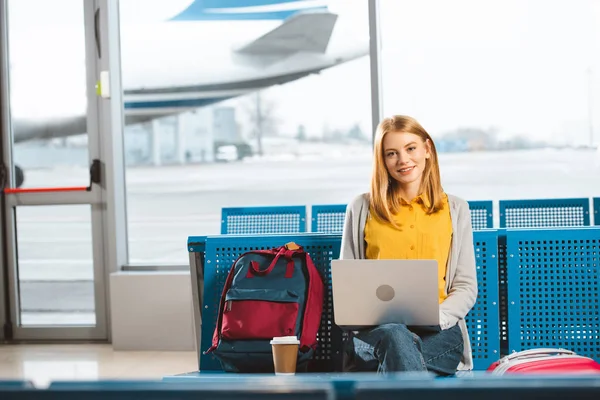 Bela Mulher Sentada Com Laptop Perto Mochila Copo Descartável Aeroporto — Fotografia de Stock