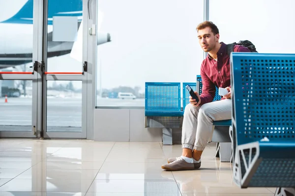 Handsome Man Holding Smartphone Passport While Sitting Departure Lounge — Stock Photo, Image