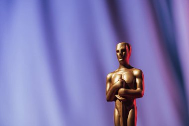 KYIV, UKRAINE - 10 HAZİRAN 2019: Mor arkaplanda fotokopi alanı ile altın oscar ödülü