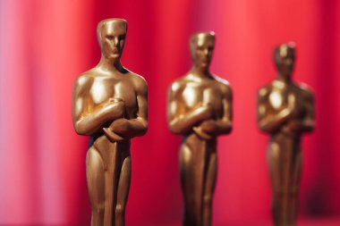 KYIV, UKRAINE - 10 HAZİRAN 2019: Kırmızı arkaplanda Altın Oscar ödüllü heykelciklere yakın çekim