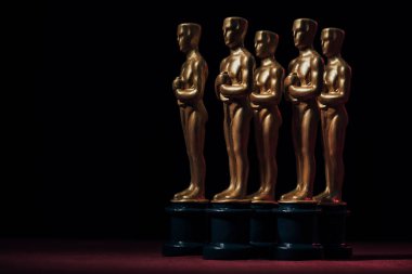 KYIV, UKRAINE - 10 HAZİRAN 2019: Siyah arkaplanda siyah arkaplan üzerine altın oscar ödüllü heykelcikler