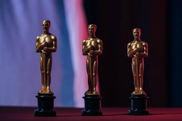 KYIV, UKRAINE - JANUARY 10, 2019: shiny golden oscar award statuettes on black background