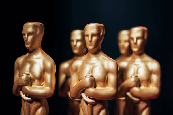 КИЕВ, УКРАИНА - 10 ЯНВАРЯ 2019 года: избирательный фокус статуэток голливудского Оскара, изолированных на черном