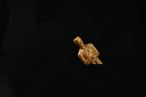 KYIV, UKRAINE - JANUARY 10, 2019: golden oscar award isolated on black with copy space