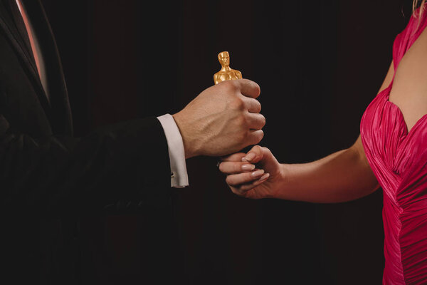 КИЕВ, УКРАИНА - 10 ЯНВАРЯ 2019 года: частичный взгляд женщины и мужчины, обладающих Оскаром, изолирован от черных