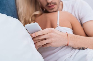 smartphone süre kucaklama kız yatakta kullanan adam kırpılmış atış