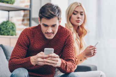 istimal smartphone vasıl ev gülümseyen erkek arıyorum ilişki sorun kavramı smartphone ile kıskanç genç kadın