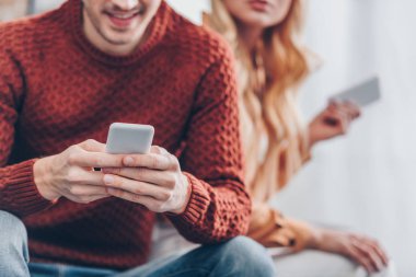 karı koca evde akıllı telefonlar kullanan genç gülümseyen in atış kırpılmış, güvensizlik kavramı