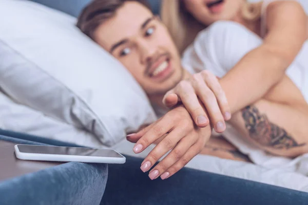 Cropped Shot Angry Man Holding Hand Wife Reaching Smartphone Bedroom — Stock Photo, Image