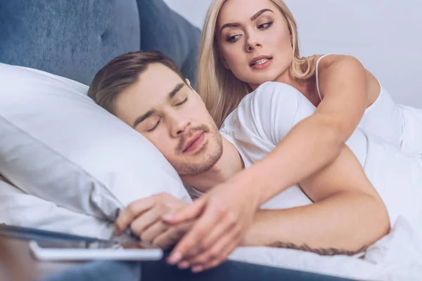 Jealous Woman Reaching Smartphone While Boyfriend Sleeping Bed — Stock Photo, Image