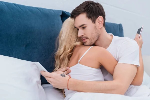 Young Couple Hugging Using Smartphones Bed Relationship Problem Concept — Stock Photo, Image