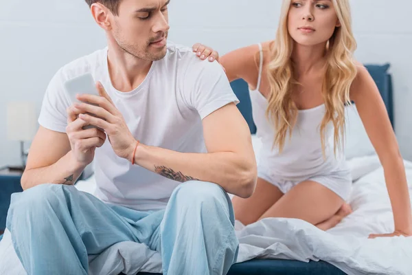 Cropped Shot Jealous Young Woman Looking Boyfriend Using Smartphone Bed — Stock Photo, Image