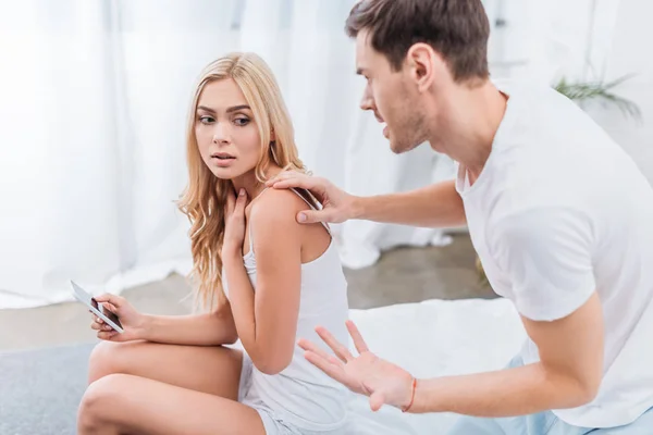 Angry Man Touching Young Wife Sitting Smartphone Bed Distrust Concept — Stock Photo, Image