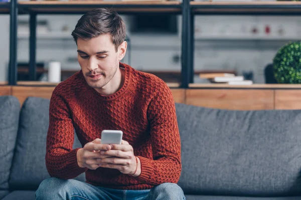 Thoughtful Young Man Sitting Sofa Using Smartphone Home — Stock Photo, Image