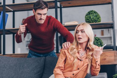 Kız koltukta, ihanet kavram smartphone kullanarak bakarak bıçaklı saldırgan adam 