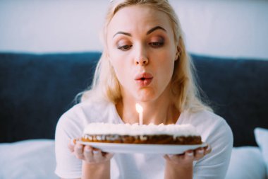 seçici odak süre yatakta yalnız Doğum günü kutlama mum kek üzerine dışarı üfleme kadının