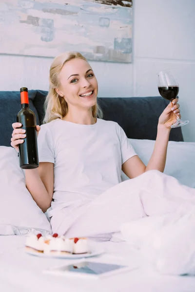 Mujer Feliz Sosteniendo Botella Copa Vino Tinto Mientras Celebra Cumpleaños —  Fotos de Stock