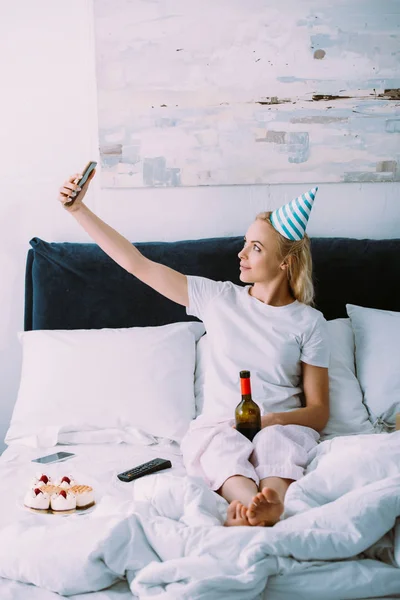 Γυναίκα Καπέλο Κόμμα Λήψη Selfie Smartphone Ενώ Γενέθλια Στο Κρεβάτι — Φωτογραφία Αρχείου