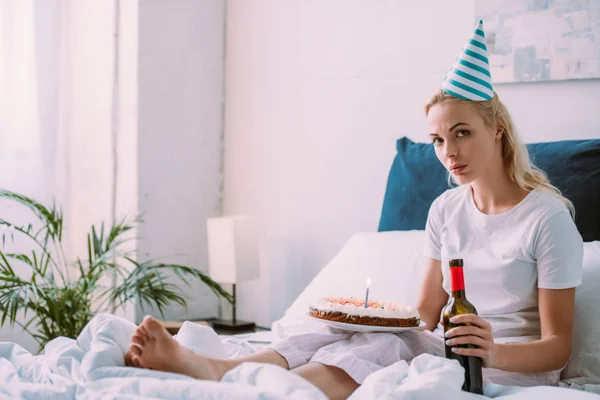 ワインと一人でベッドの中の誕生日を祝ってケーキを持つ女性を混乱させる — ストック写真