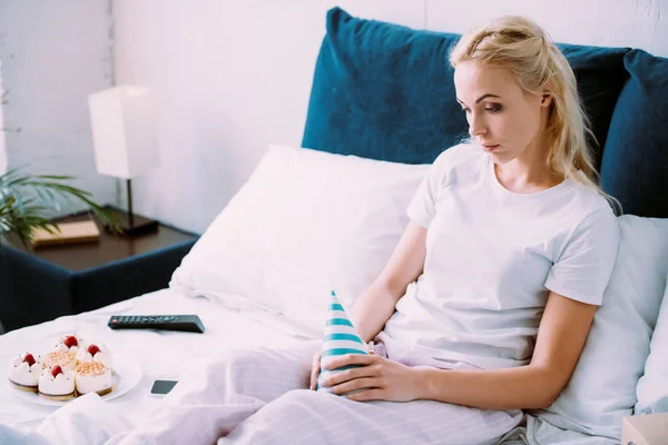 Uspet Woman Holding Party Hat While Celebrating Birthday Bed Alone — Stock Photo, Image