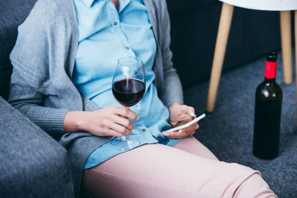 Vista Cortada Mulher Segurando Copo Vinho Usando Smartphone Casa — Fotografia de Stock