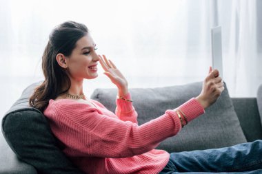 gülümseyen Hintli kadın sallayarak ve dijital tablet üzerinde video arama yapma