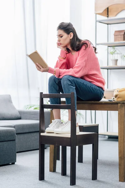 Fundersam Kvinnlig Indisk Student Läser Bok Hemma — Stockfoto