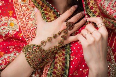 cropped view of woman posing in traditional indian sari and accessories, isolated on grey  clipart