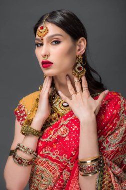 geleneksel elbise ve aksesuarlar, gri izole poz çekici Hintli kadın 
