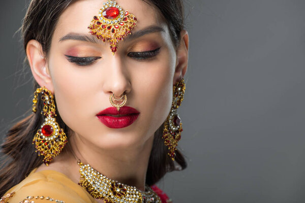 beautiful indian woman posing in traditional bindi, isolated on grey 