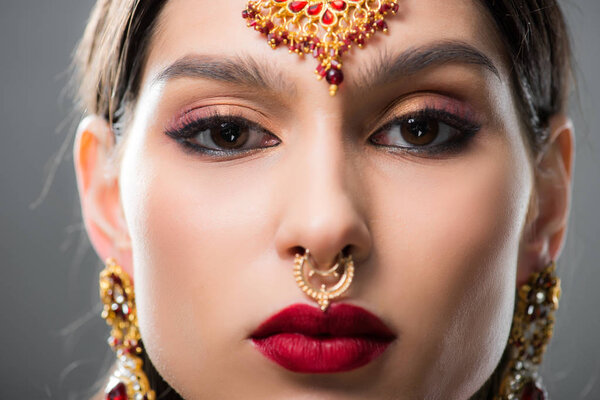 красивая индийская женщина в традиционном бинди, изолированная на сером
 