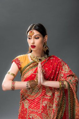 namaste mudra, gri izole ile geleneksel giyim güzel Hintli kadın 