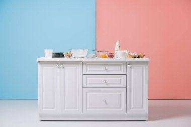 çeşitli pişirme aletleri ve ürünleri bicolor arka plan üzerinde beyaz mutfak masası