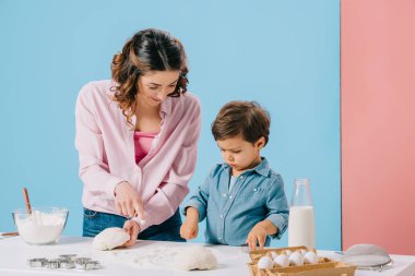 sevimli küçük yapma pasta bicolor arka plan üzerinde beyaz mutfak masasında annesiyle 
