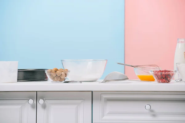 さまざまな製品やバイカラーの背景に白のキッチン テーブルの上の調理器具 — ストック写真
